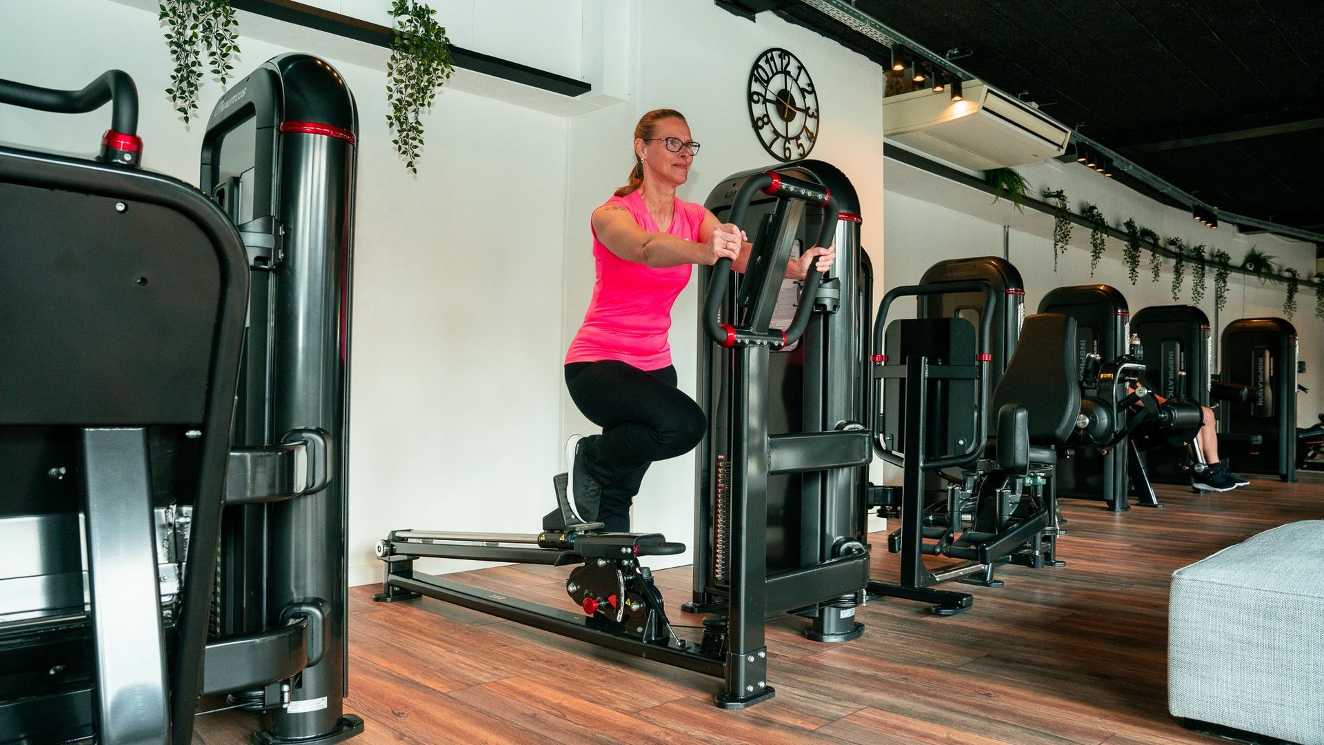 Een vrouw gebruikt een apparaat in een sportschool.