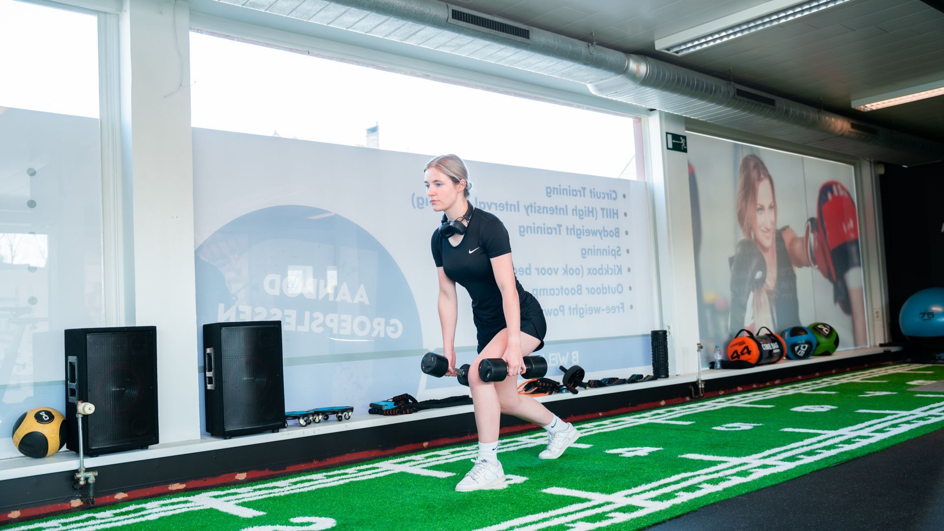 Een vrouw tilt een halter op in een sportschool.