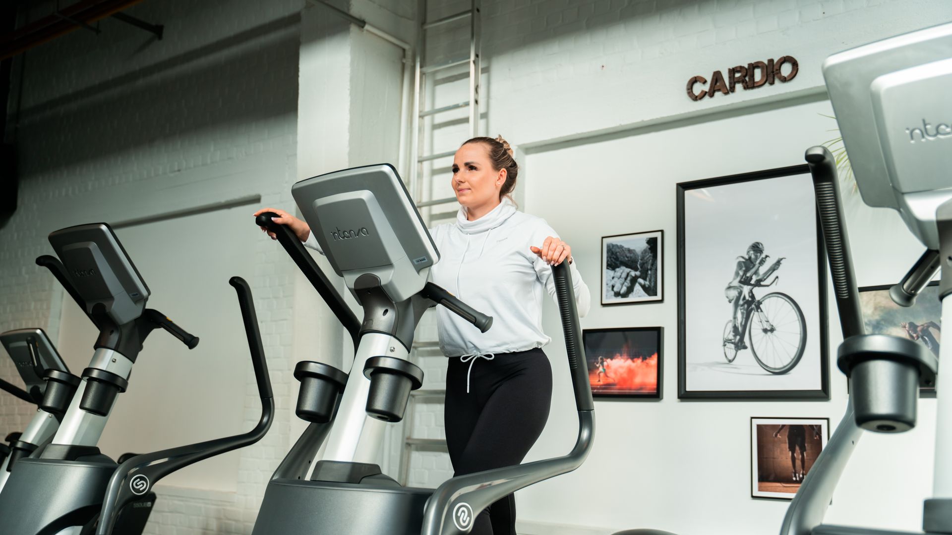 Een vrouw rijdt op een crosstrainer in een sportschool.