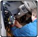 Person in blue shirt working on car dashboard. | Quality Car & Truck Repair