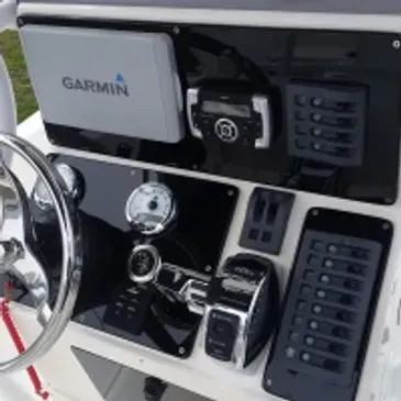 Boat dashboard with Garmin display, steering wheel, gauges, and control switches