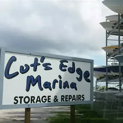 Cut's Edge Marina sign with storage and repairs text beside a marina structure