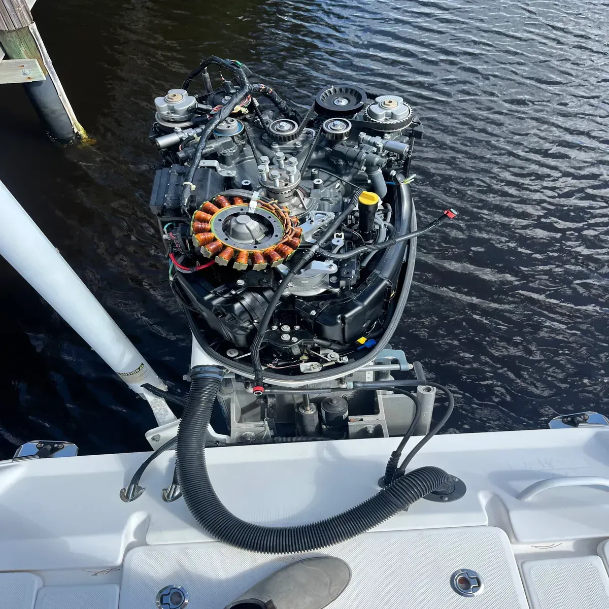 Marine engine mounted at the stern of a boat beside dark rippling water