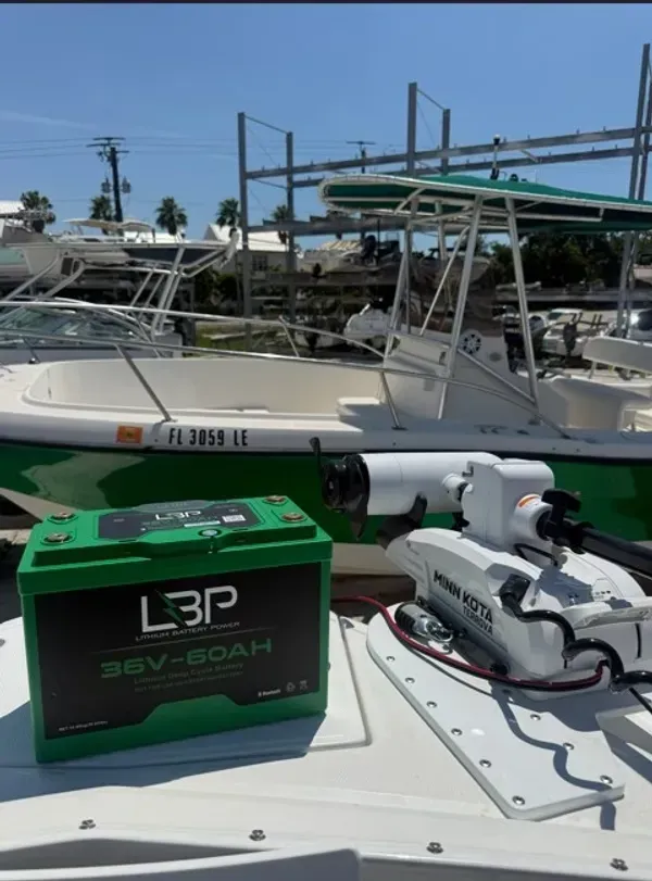Green L3P battery on a boat deck beside a marina under a blue sky