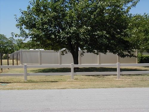 A white fence with a tree in the background