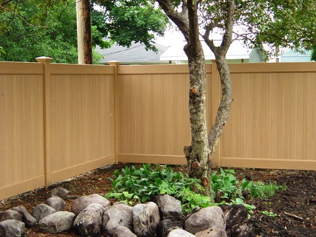 A wooden fence with a tree in the middle of it.