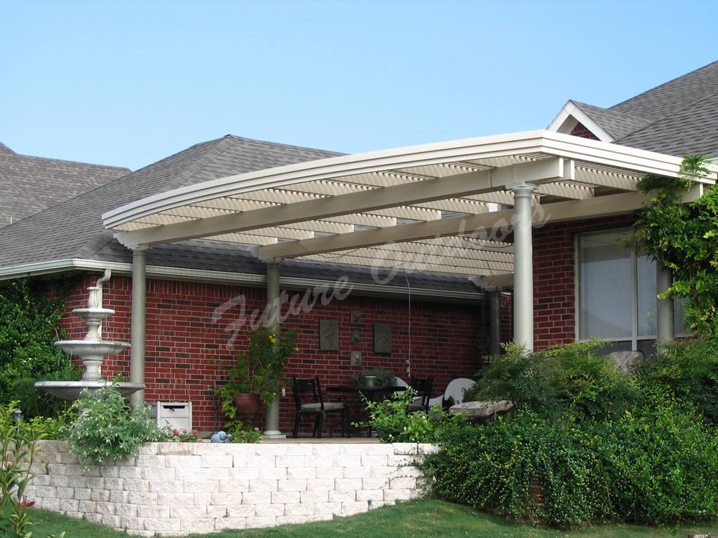 A brick house with a white pergola on top of it