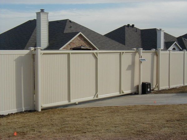 A white fence in front of a row of houses