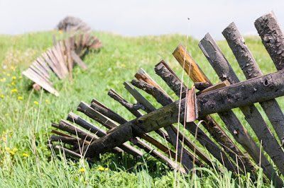 A wooden fence is sitting in the middle of a grassy field.