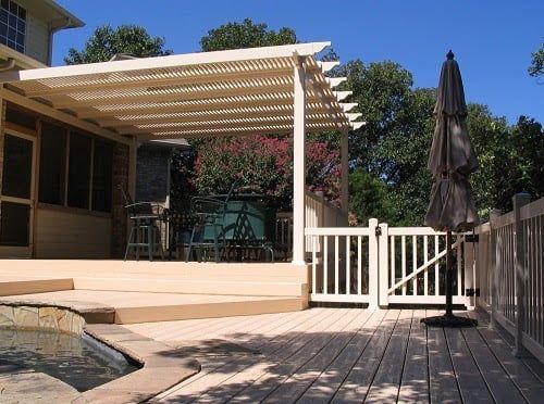 A deck with a pergola and umbrella on it
