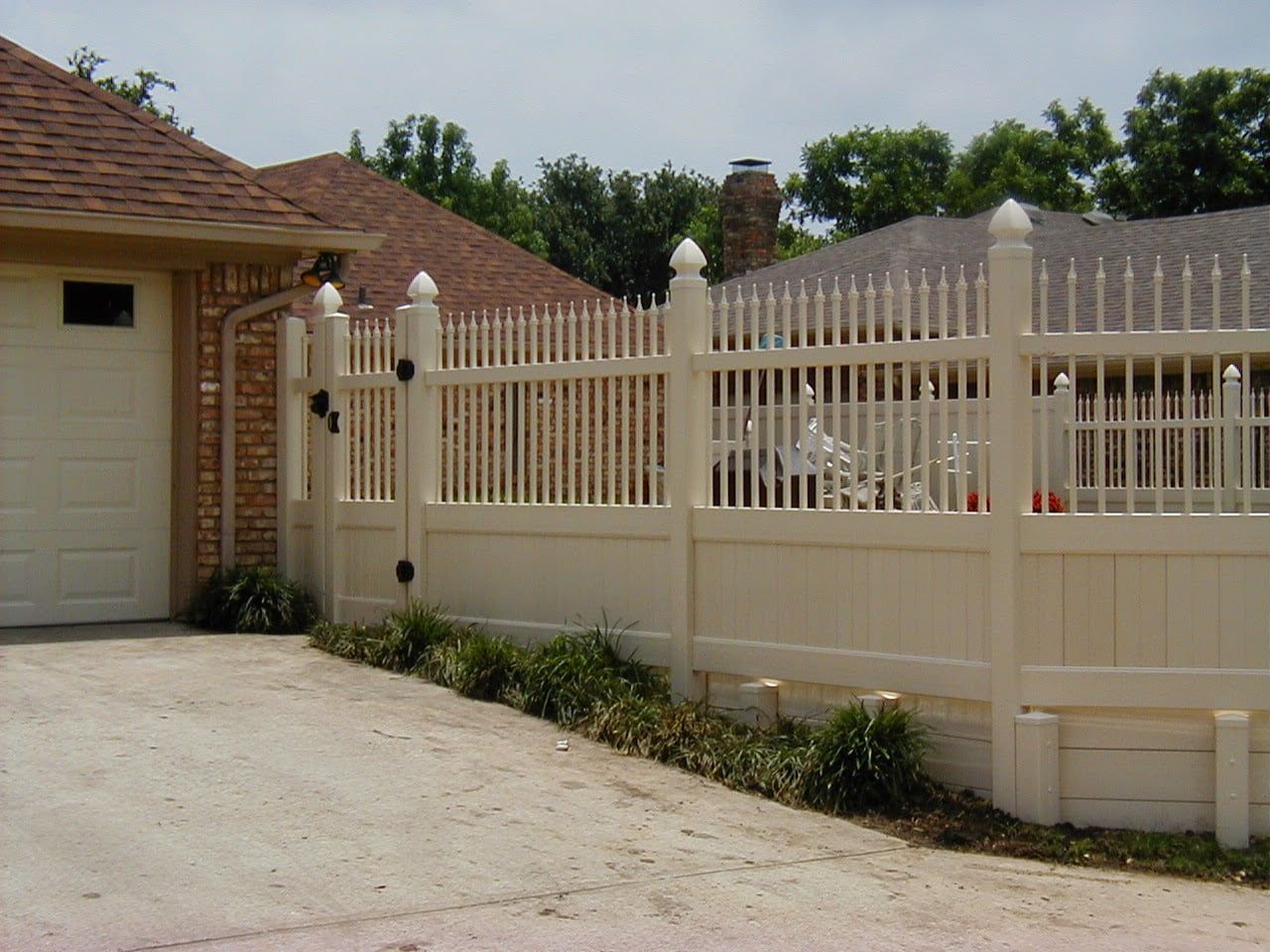 A white fence with a gate in front of a house