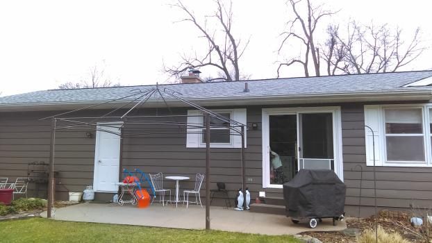 The back of a house with a patio and a grill.