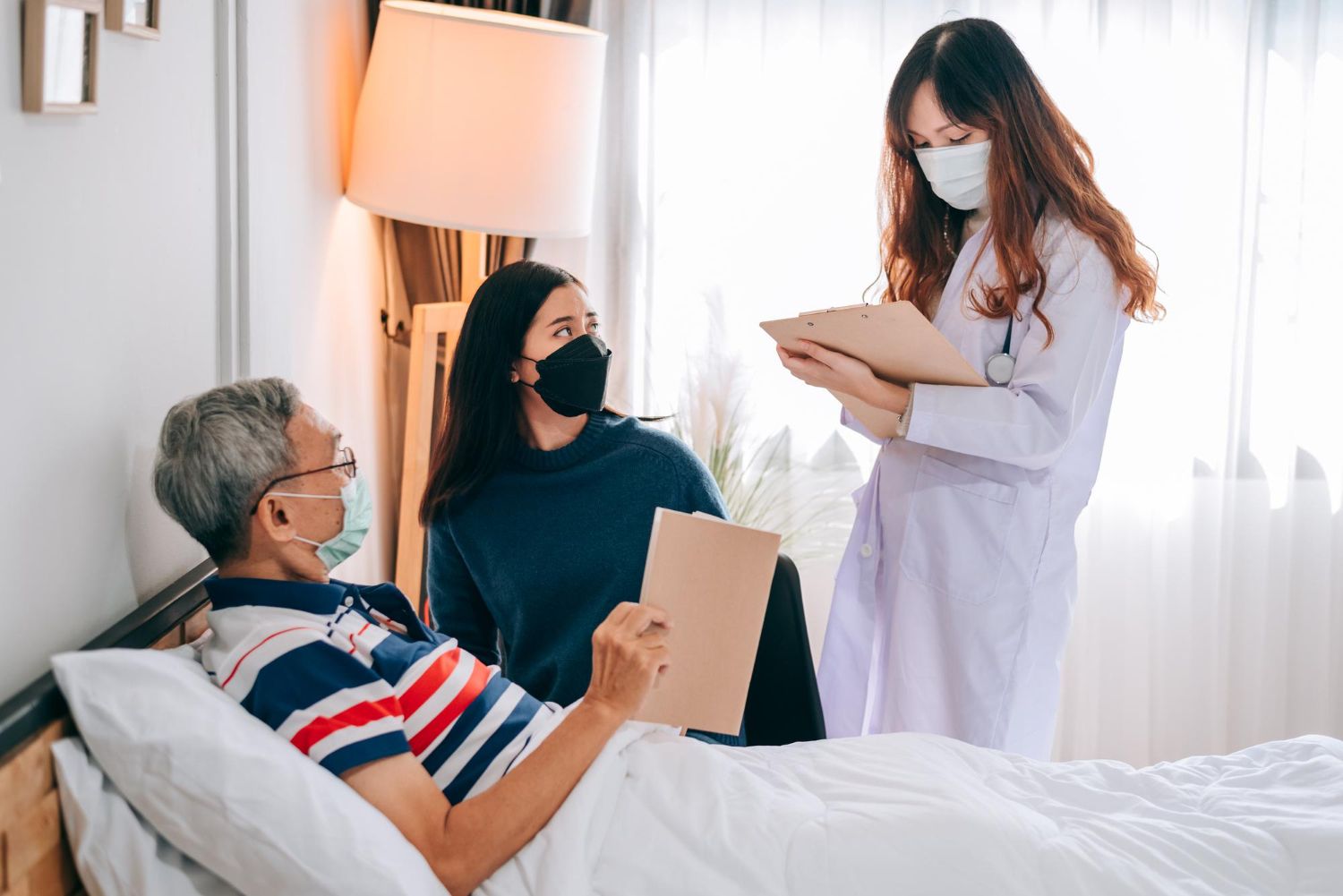 A doctor is talking to a patient in a hospital bed.