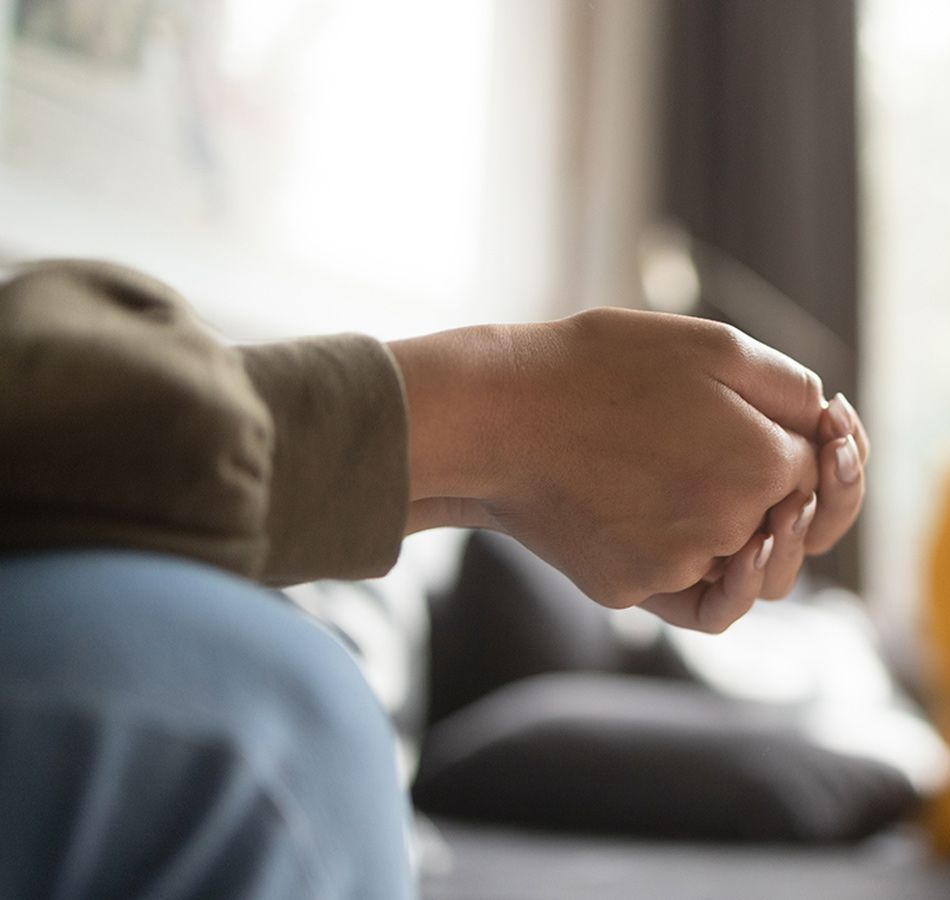 Two people sitting close, holding hands, in a calm indoor setting