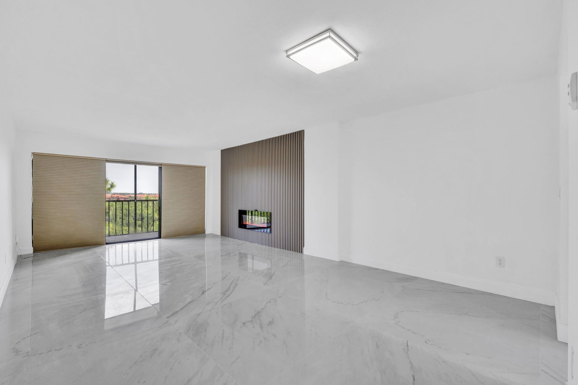 Bright empty modern room with glossy white floors, striped curtains, and a balcony view