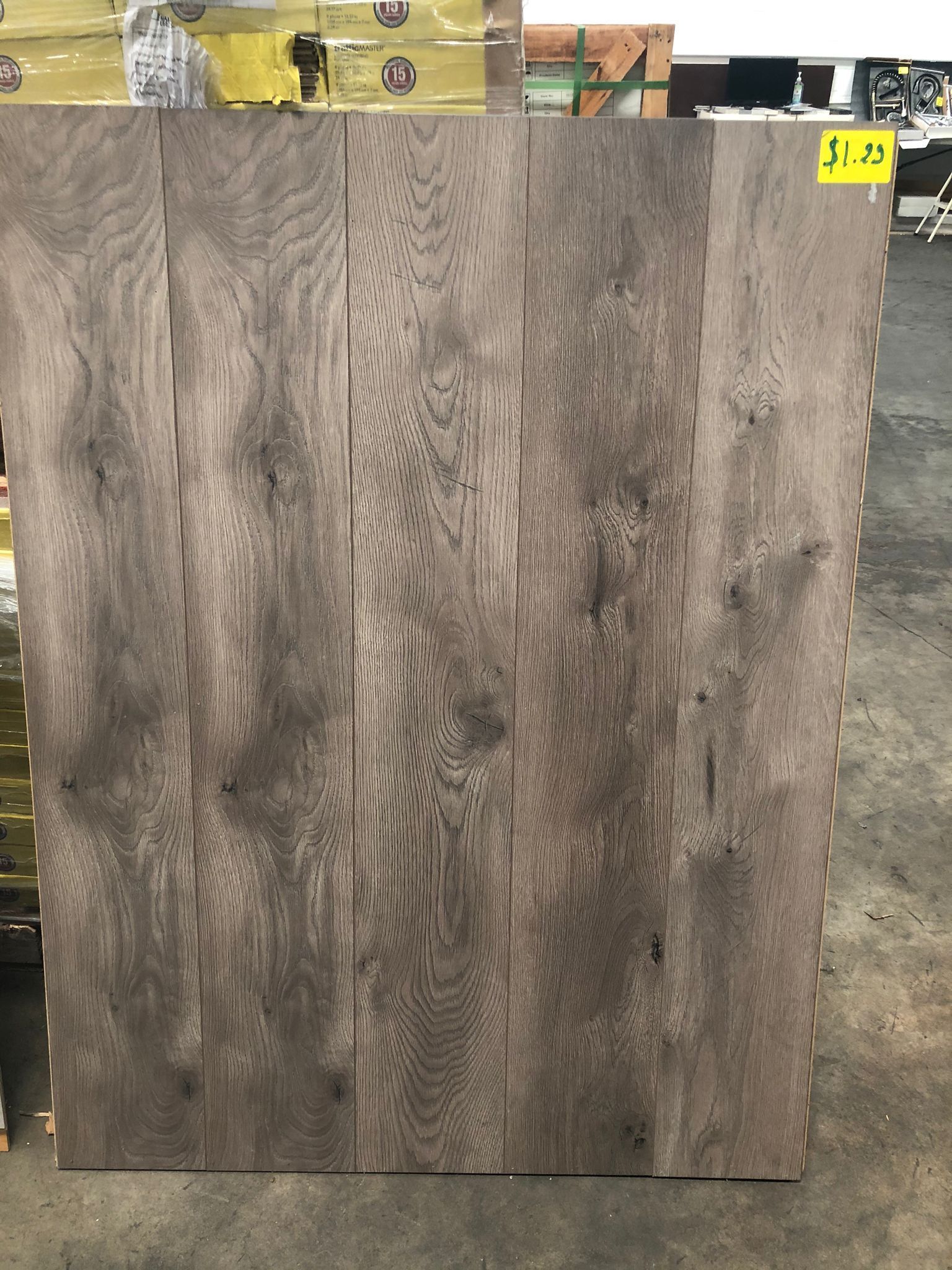 Large gray-brown wood-look panel displayed upright in a store aisle.