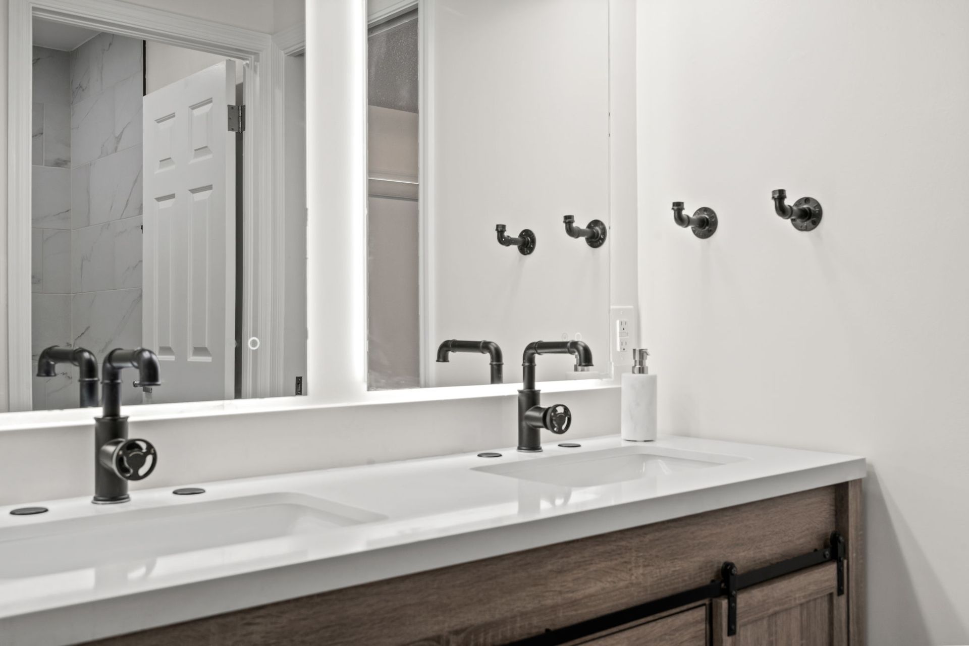 Modern bathroom vanity with white sink, black faucet, mirror, and dark wood cabinet
