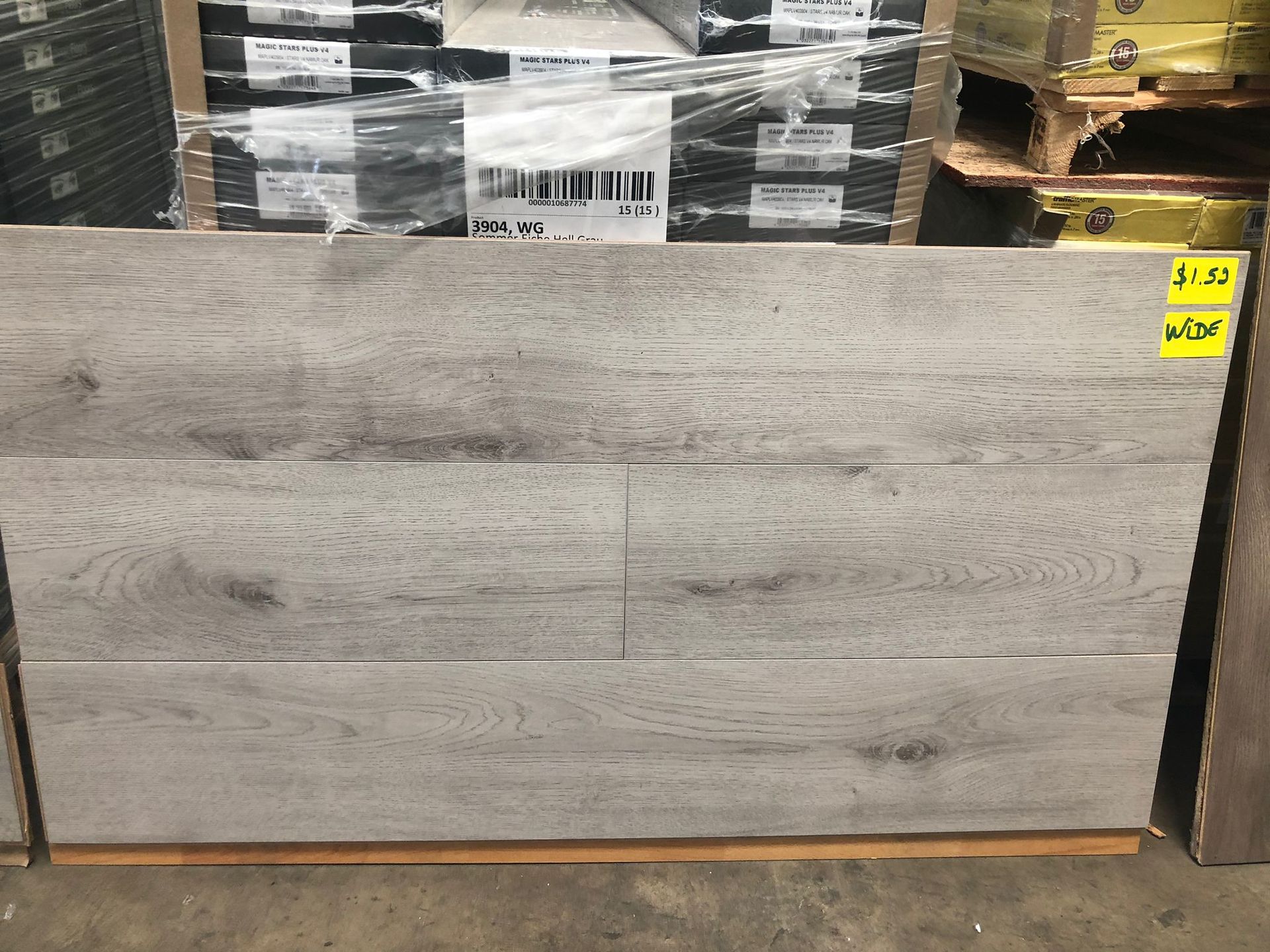Gray wood-look panel leaning against pallets in a warehouse aisle