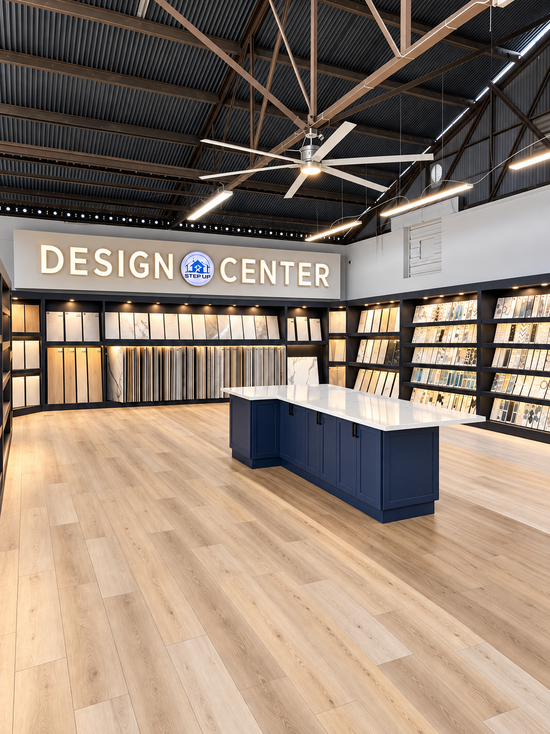 Modern design center showroom with wood floors, blue display tables, and illuminated wall panels