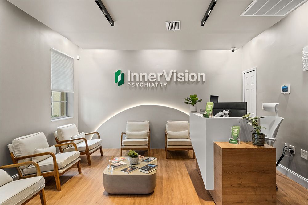 Modern eye clinic waiting room with white chairs, wood flooring, reception desk, and “Inner Vision” sign