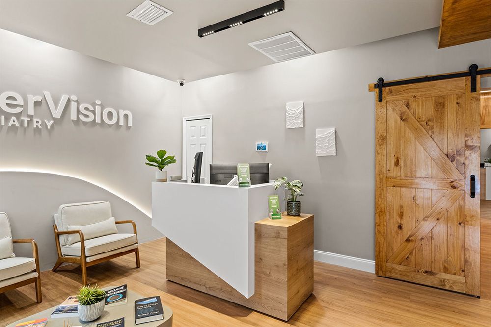 Modern office reception area with white desk, wood accents, seating, and a sliding barn door