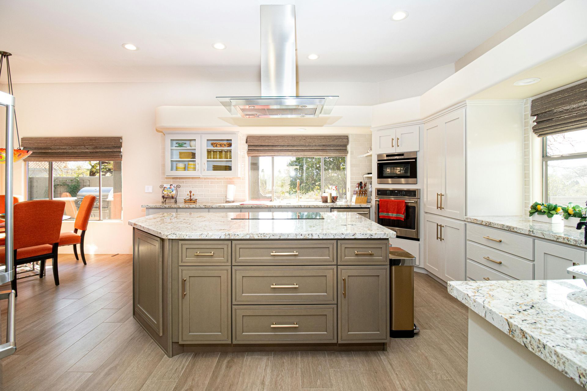 Bright modern kitchen with large island, white cabinets, stainless appliances, and an adjoining dining area