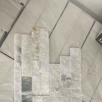Gray stone tiles laid out on a tiled floor, forming a stepped rectangular pattern