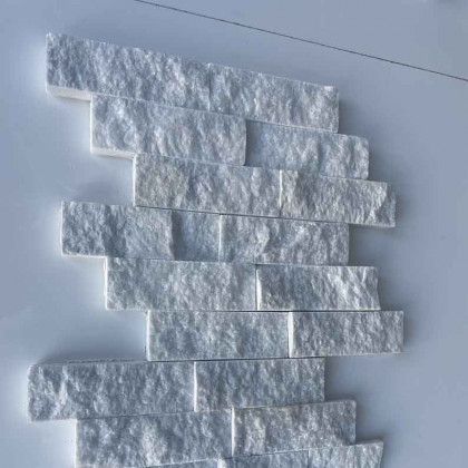 White textured brick pattern on a light wall, forming a staggered vertical column.