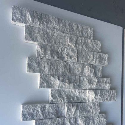Stack of white textured paper strips arranged diagonally on a light gray surface.