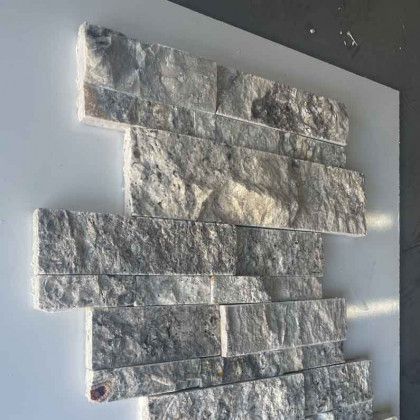 Stacked gray stone veneer tiles mounted on a white panel