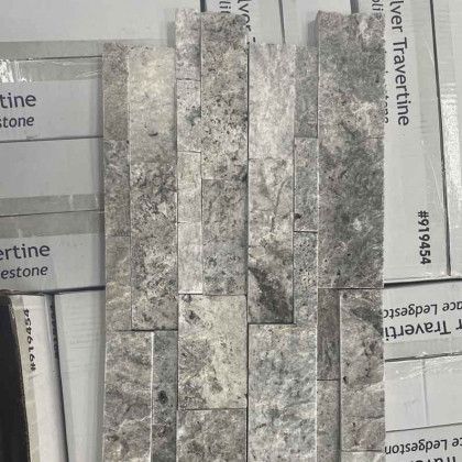 Gray stone tile samples arranged in a vertical mosaic on a store display board
