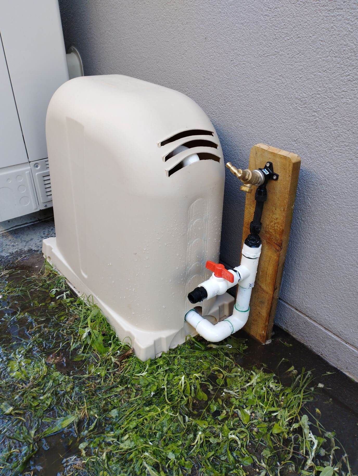 picture of a fresh water bore installed in Mount Maunganui. Beige cover with PVC plumbing to an irrigation system