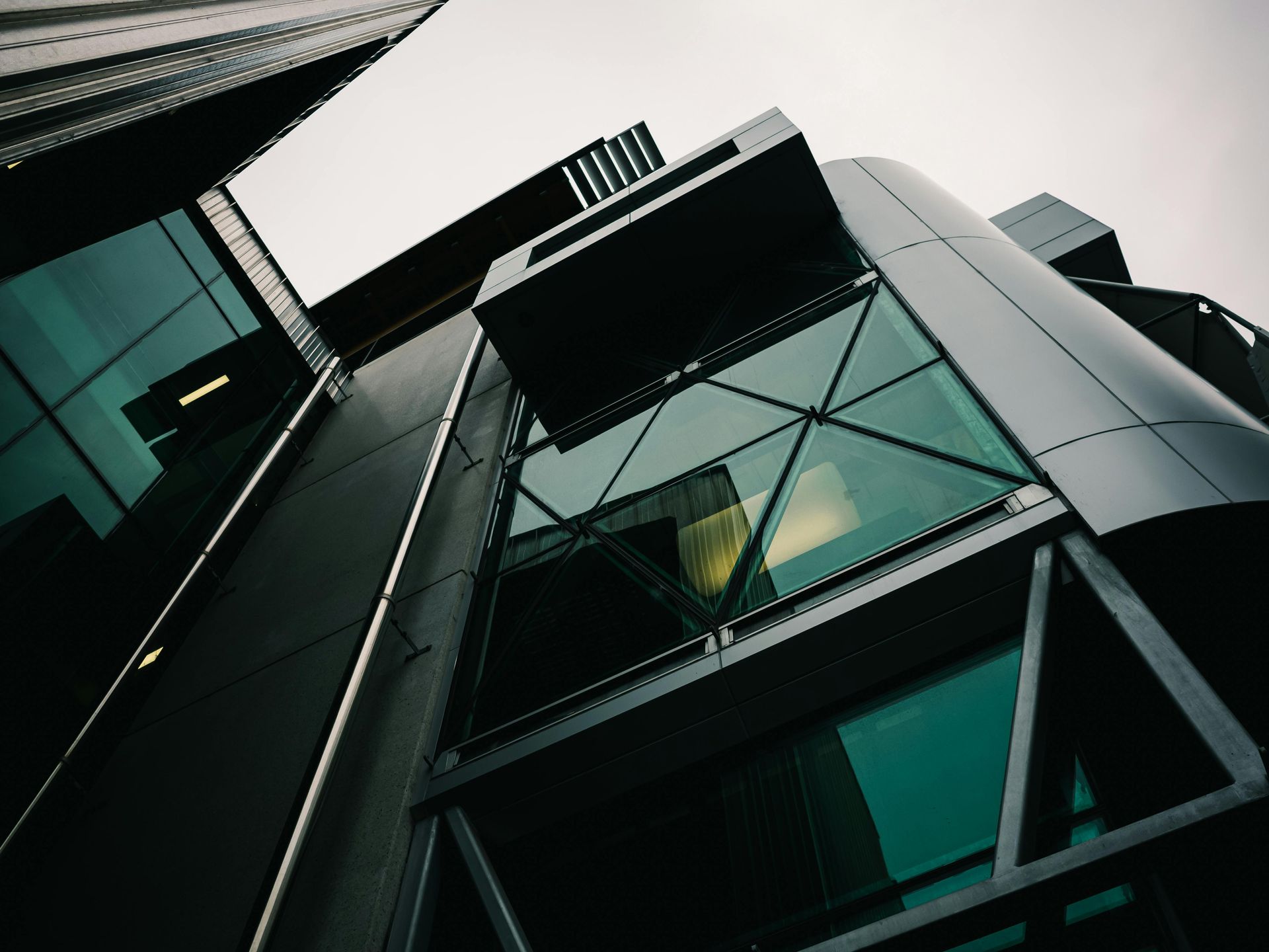 Looking up at a tall glass building with a blue sky in the background