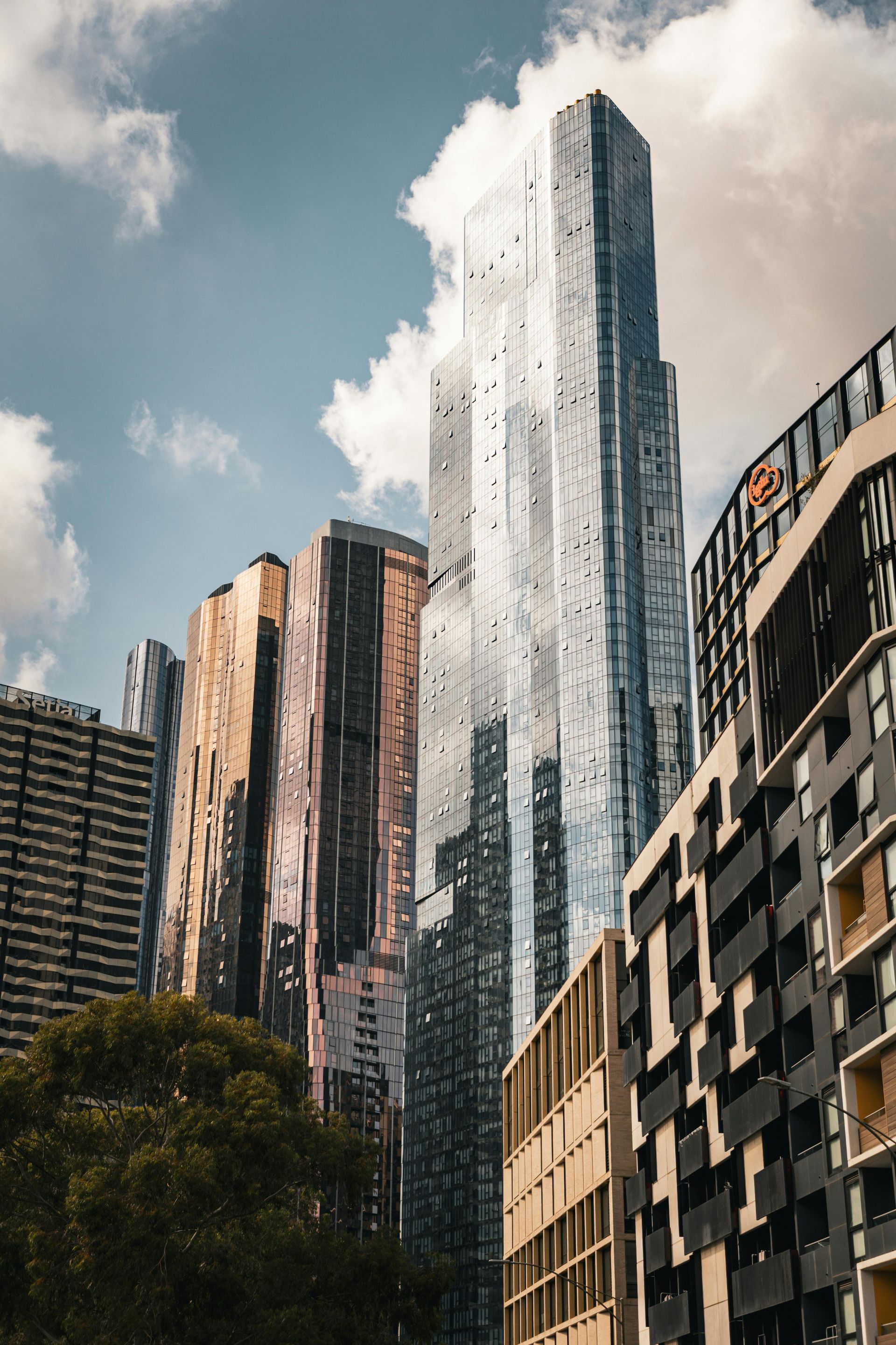 Looking up at a tall glass building with a blue sky in the background