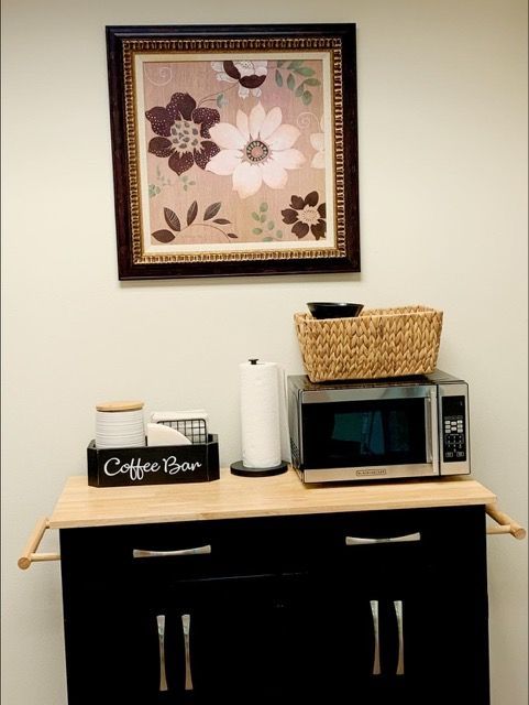 A coffee brew sign sits on a counter next to a microwave