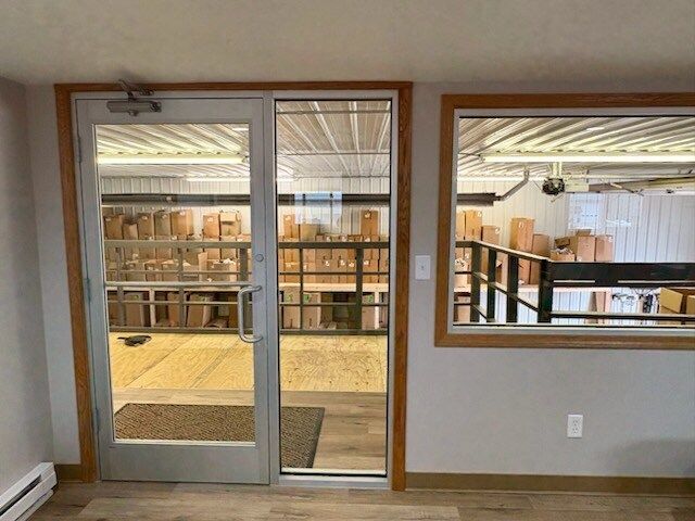 Glass doors and window with wooden trim, looking into an interior storage space filled with boxes.