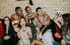 Candid moment with a group of friends using the props at the photo booth station during the party
