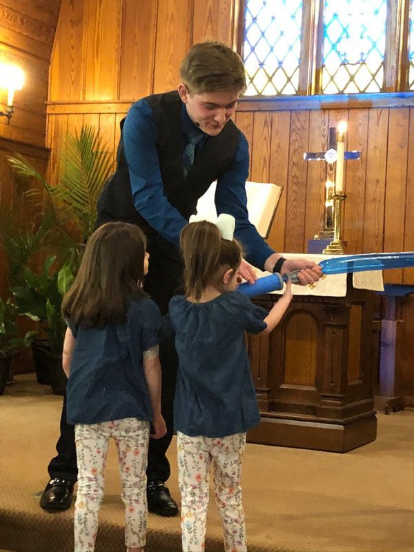 A man and two little girls are standing in a church.