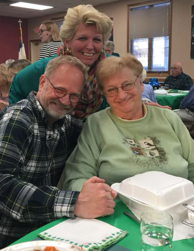 A man and two women are posing for a picture at a table