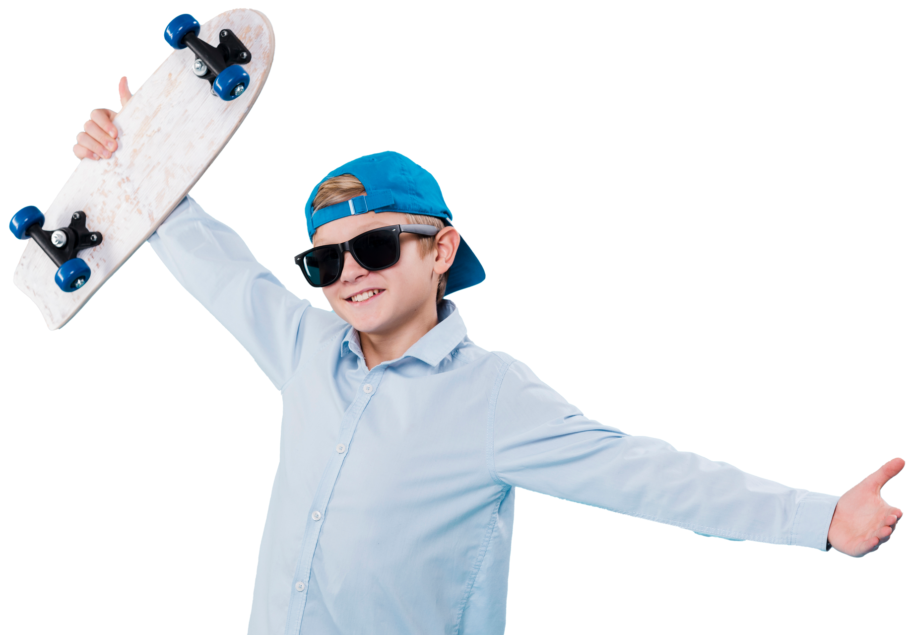 A young boy wearing sunglasses and a hat is holding a skateboard over his head.