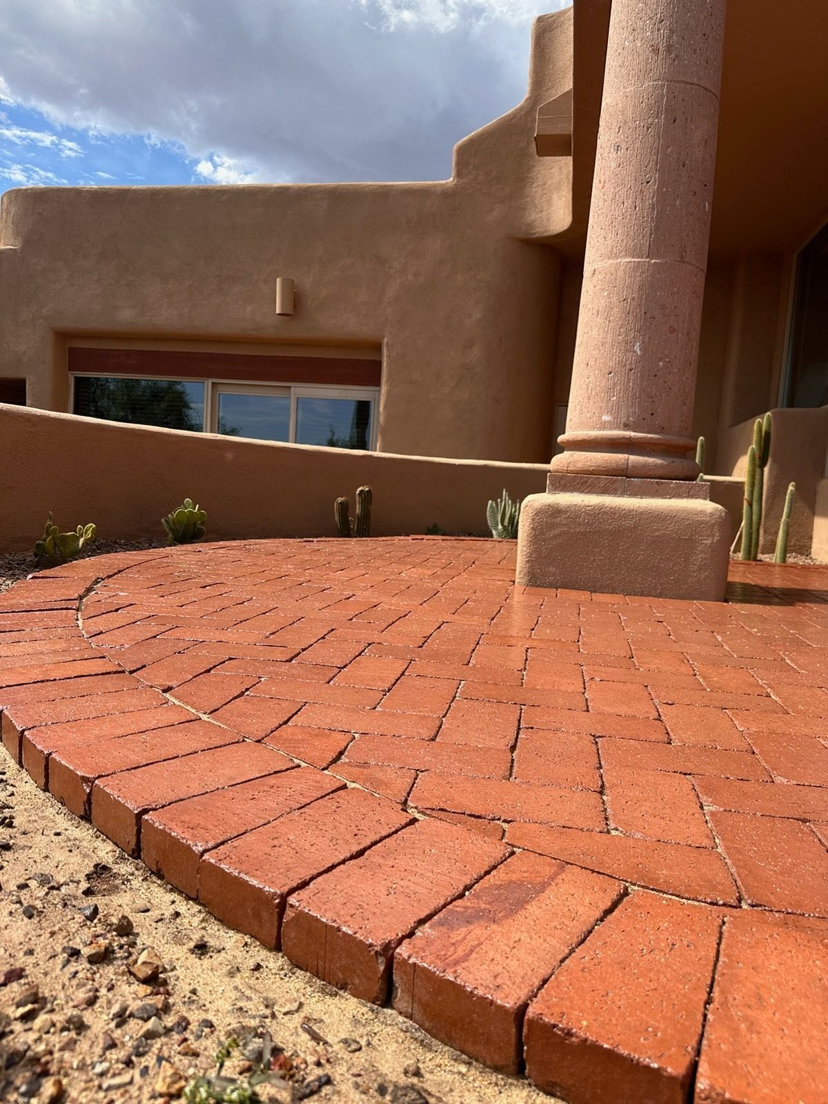 Red brick building with gray roof, white accents, and a clear blue sky.