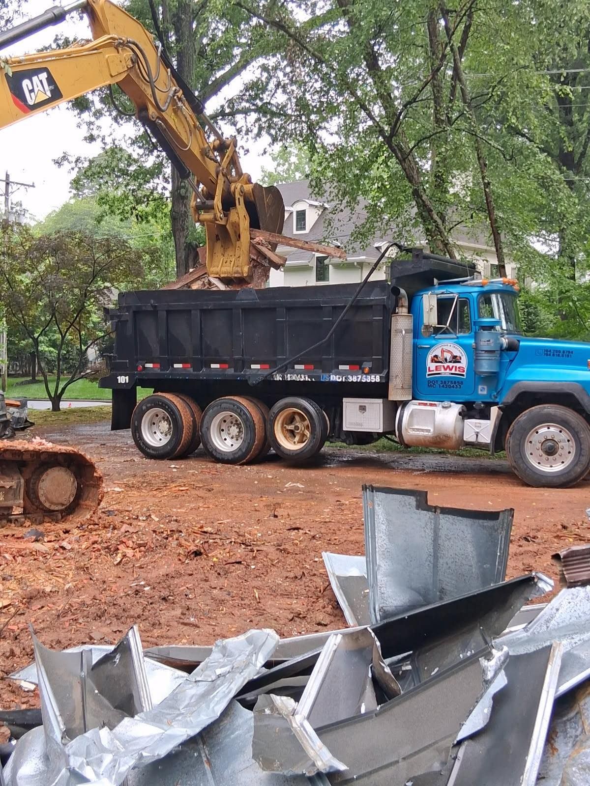Yellow excavator removing junk and placing into blue pickup truck 