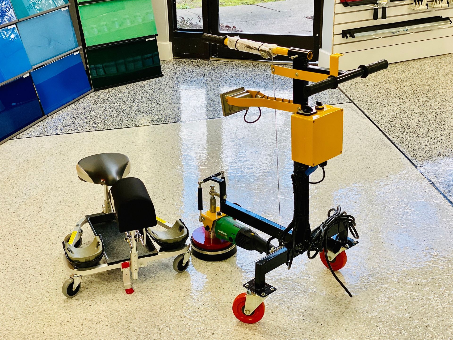 Two small wheeled robots, one black and one orange, on a tiled floor in a lab or classroom.