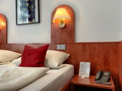 Ein Hotelzimmer mit einem Bett und einem Telefon auf einem Nachttisch