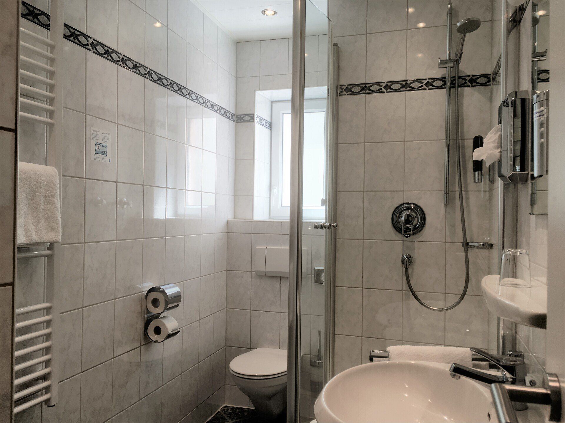 Ein Badezimmer mit Toilette, Waschbecken und Dusche.