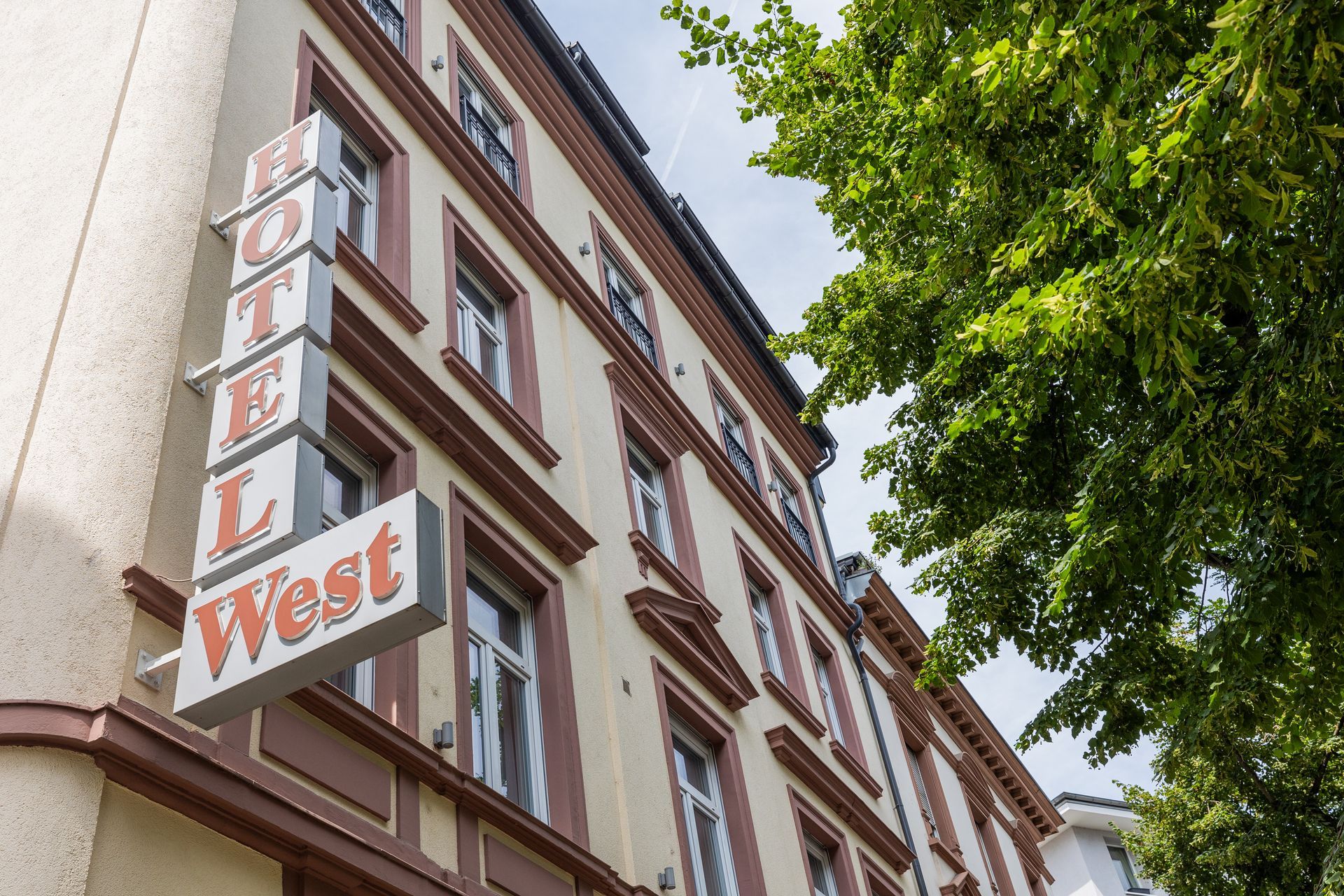 Ein großes Gebäude mit einem Schild mit der Aufschrift „Hotel West“