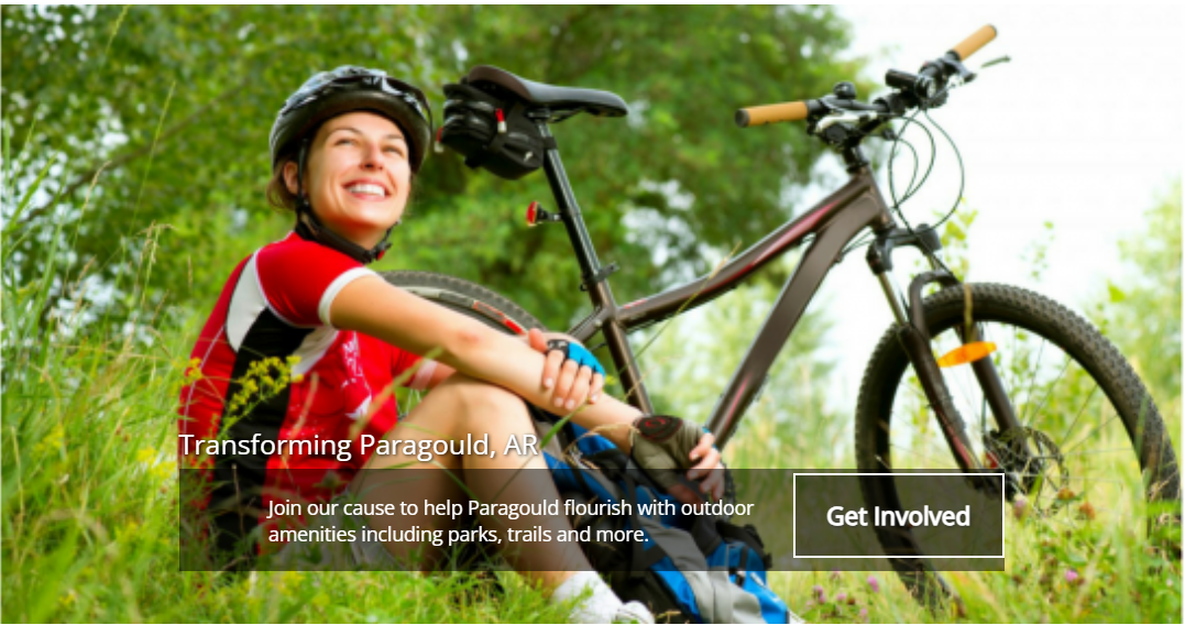 Smiling cyclist resting with a mountain bike in a grassy field, with a “Get involved” banner.