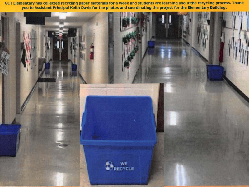 Blue recycling bin in a school hallway with posters on the walls and shiny floors.