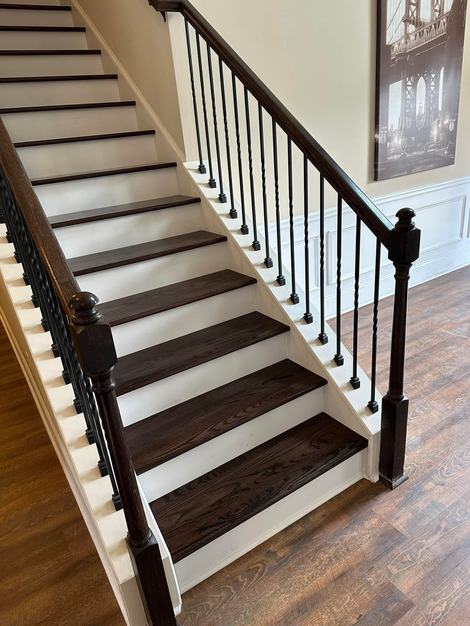 a white staircase with brown steps and a black railing