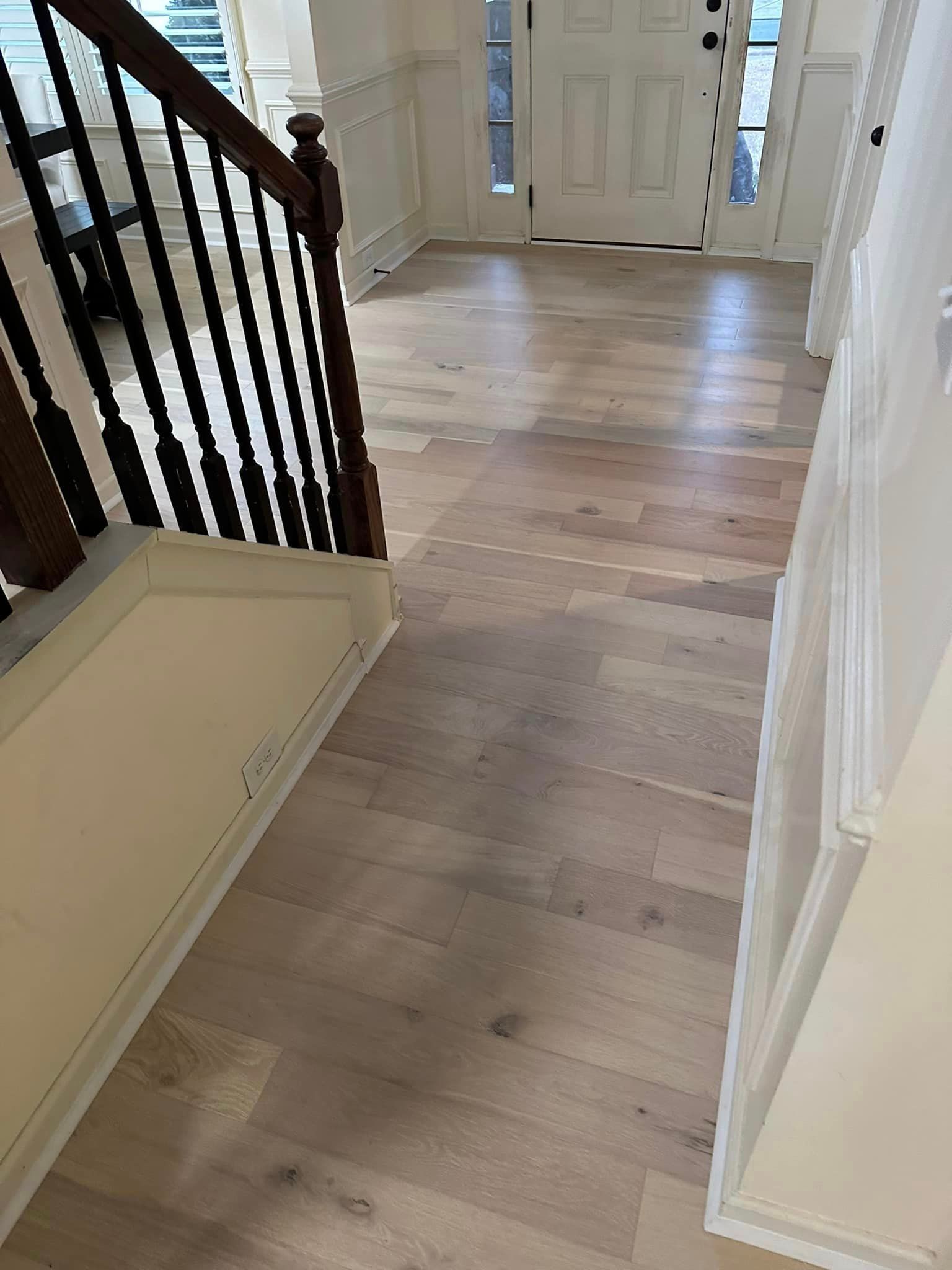 a hallway with hardwood floors and stairs in a house .
